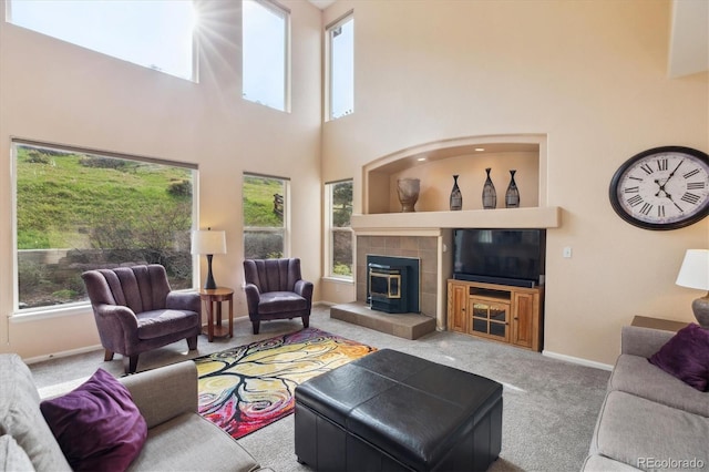 carpeted living area featuring baseboards and a high ceiling