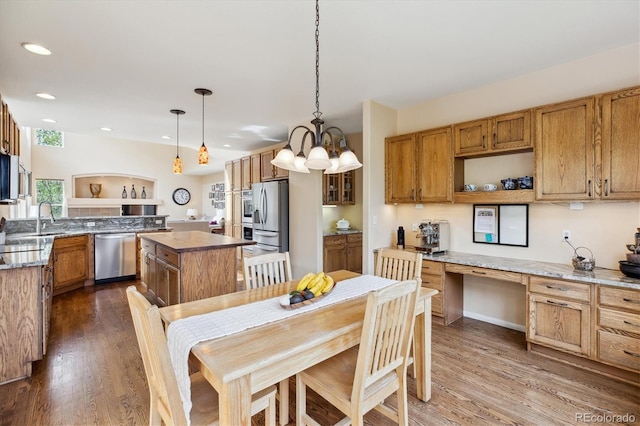 kitchen with a notable chandelier, recessed lighting, a center island, appliances with stainless steel finishes, and dark wood-style floors