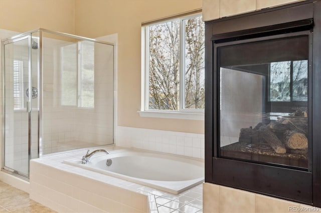 full bathroom with a stall shower, a healthy amount of sunlight, and a bath
