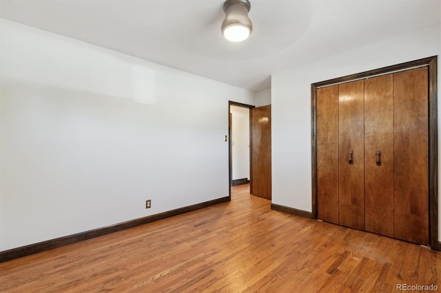 unfurnished bedroom with a closet and light wood-type flooring