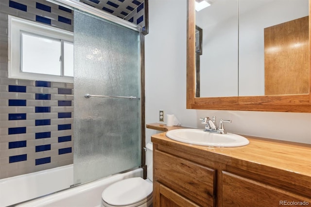 full bathroom featuring enclosed tub / shower combo, vanity, and toilet