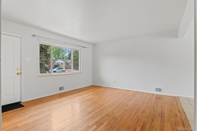 empty room with light wood finished floors and baseboards