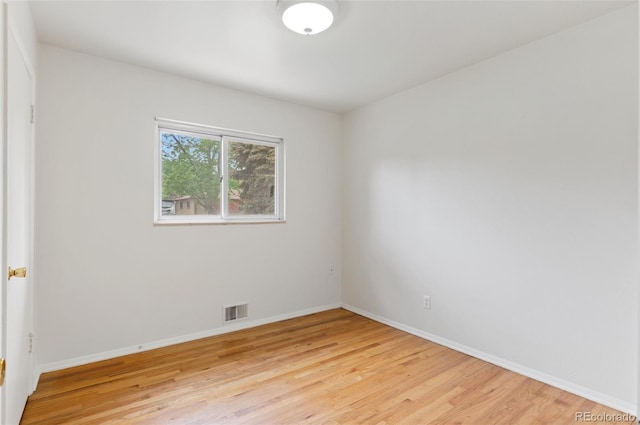 spare room featuring light wood-type flooring and baseboards