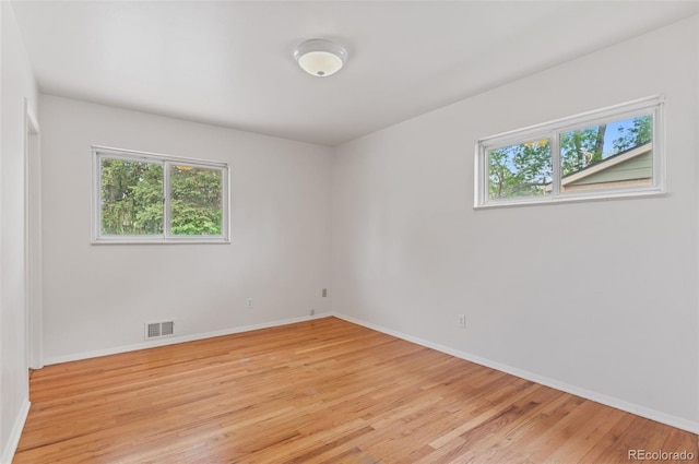 empty room featuring light wood-type flooring and baseboards