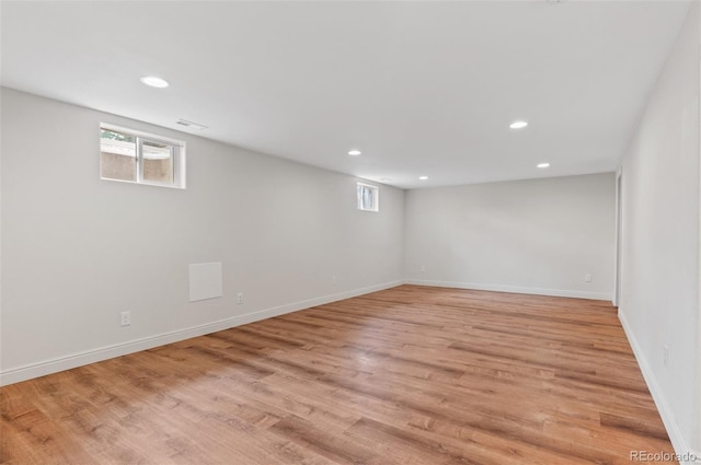 below grade area with plenty of natural light, light wood-style flooring, recessed lighting, and baseboards