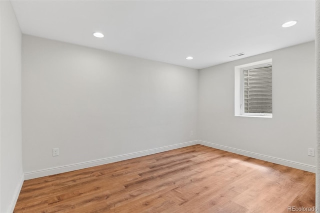 empty room with light wood finished floors, baseboards, and recessed lighting