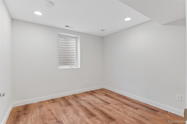 empty room with light wood-type flooring, baseboards, and recessed lighting
