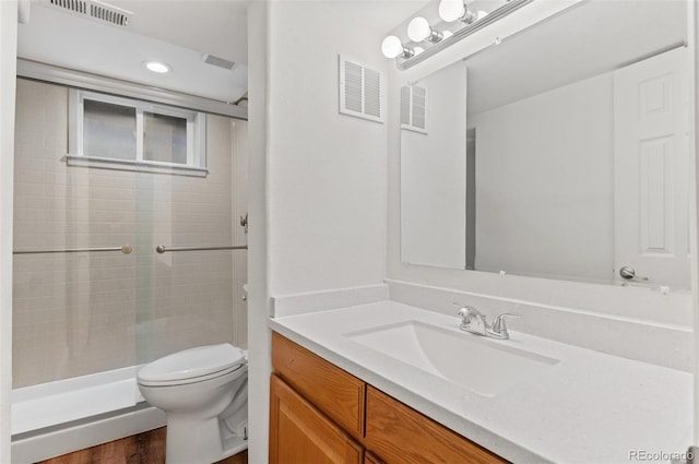 full bath featuring toilet, a shower stall, vanity, wood finished floors, and recessed lighting