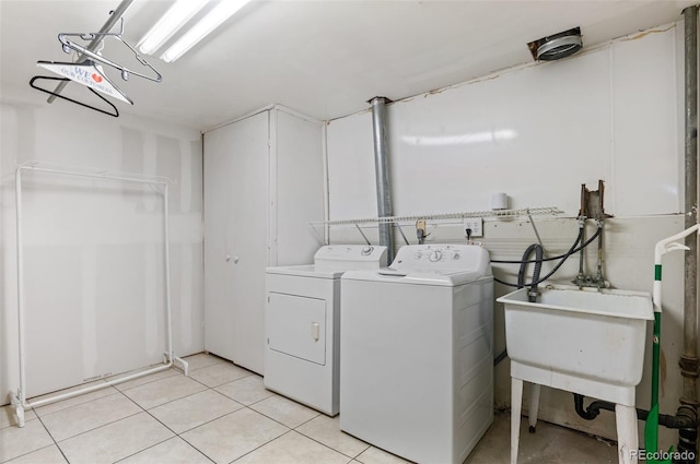 laundry room featuring washer and clothes dryer and light tile patterned flooring