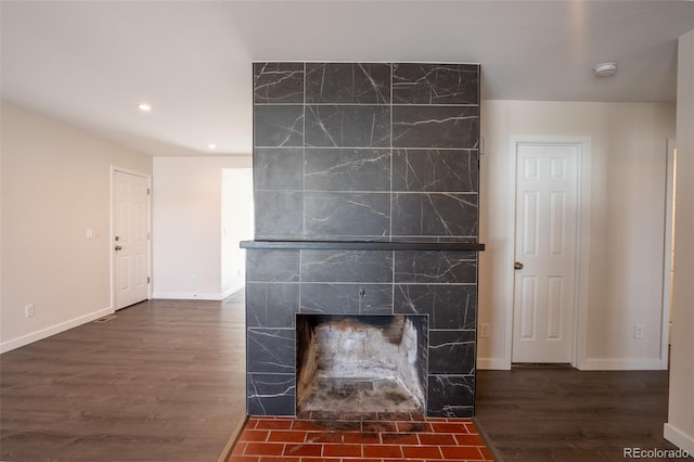 interior details with baseboards, recessed lighting, a premium fireplace, and wood finished floors