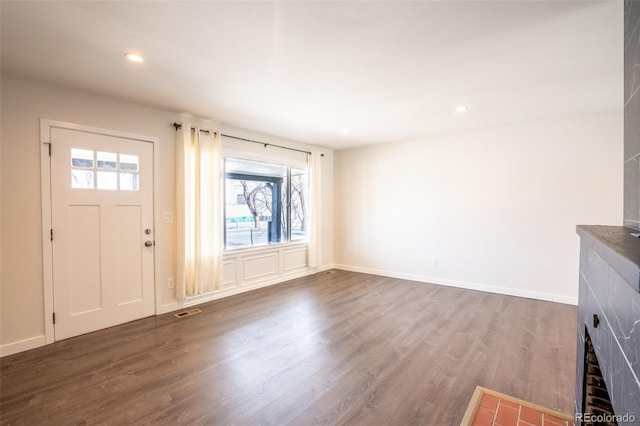 unfurnished living room featuring a wealth of natural light, recessed lighting, visible vents, and dark wood-style floors