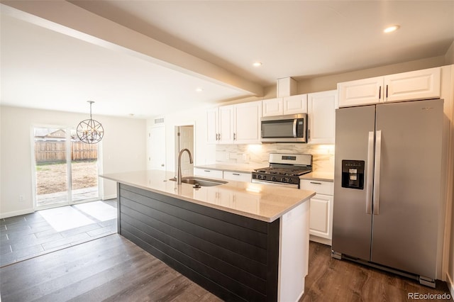 kitchen featuring tasteful backsplash, a sink, dark wood-style floors, white cabinetry, and stainless steel appliances
