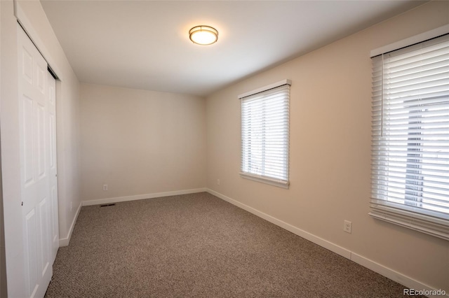 unfurnished bedroom featuring a closet, baseboards, and carpet flooring