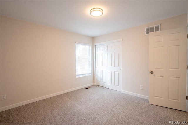 unfurnished bedroom with visible vents, baseboards, carpet flooring, and a closet