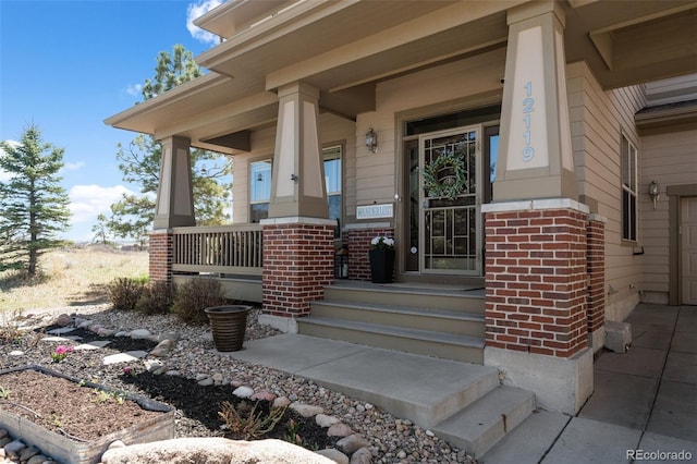 property entrance with covered porch and brick siding