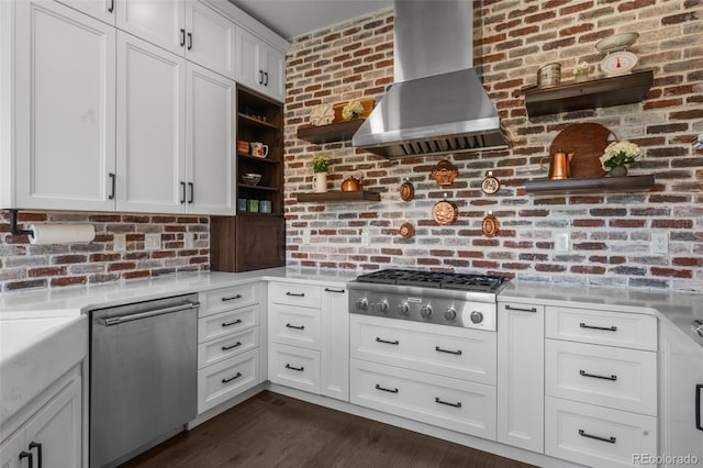 kitchen featuring appliances with stainless steel finishes, wall chimney exhaust hood, open shelves, light countertops, and white cabinets
