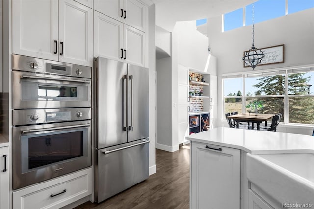 kitchen with appliances with stainless steel finishes, plenty of natural light, light countertops, and white cabinetry
