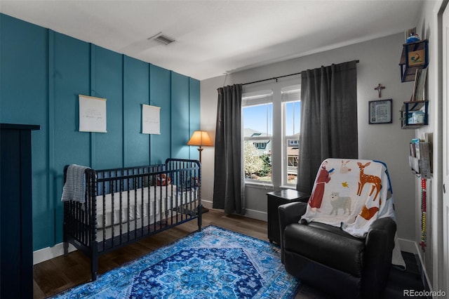 bedroom with wood finished floors and baseboards