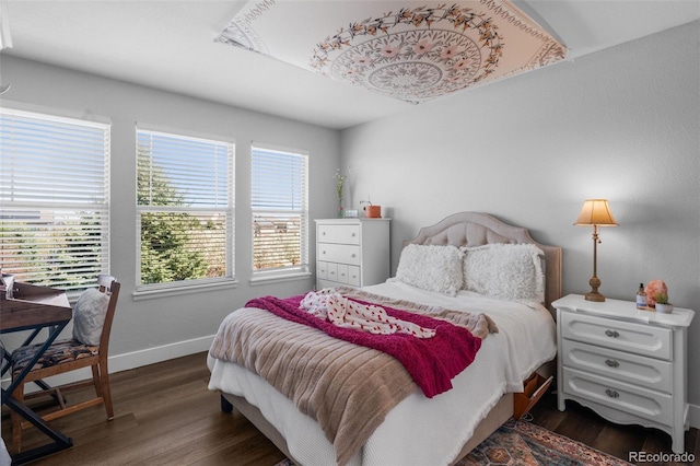 bedroom featuring dark wood finished floors and baseboards