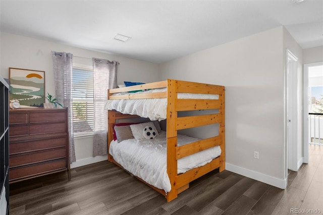 bedroom featuring baseboards and dark wood-style flooring