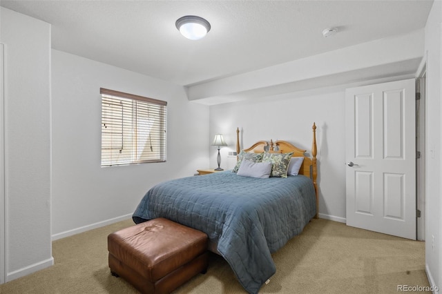 bedroom featuring light carpet and baseboards