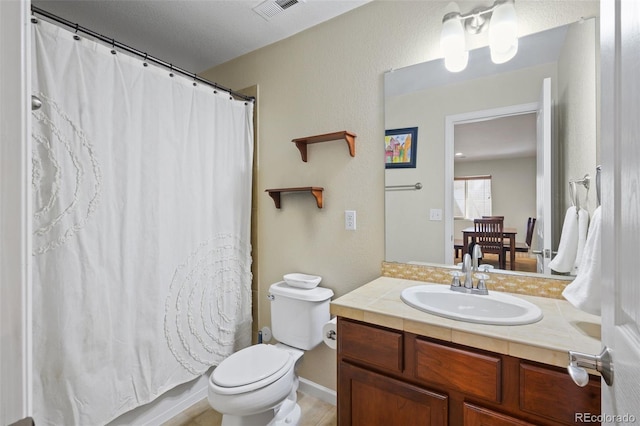 bathroom with vanity, toilet, and baseboards