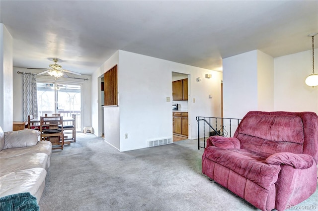 living room featuring a ceiling fan, light colored carpet, and visible vents