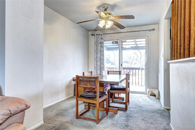 carpeted dining area featuring a ceiling fan and baseboards