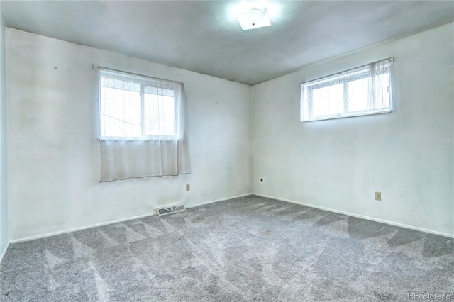 carpeted empty room featuring visible vents