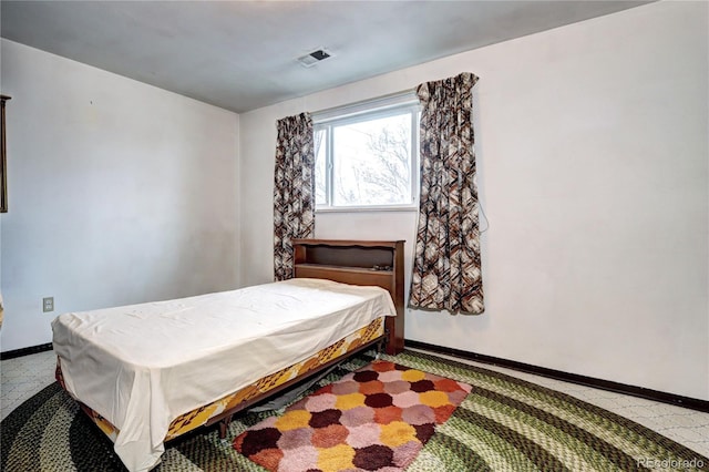 bedroom featuring tile patterned floors, visible vents, and baseboards