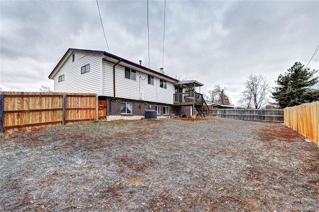 back of property featuring brick siding, central AC, and a fenced backyard