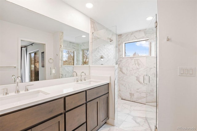 bathroom featuring double vanity, a sink, marble finish floor, and a marble finish shower