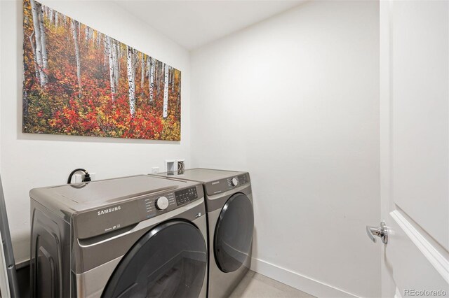clothes washing area with baseboards, laundry area, and washing machine and clothes dryer