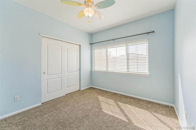 unfurnished bedroom featuring baseboards, carpet, and a closet