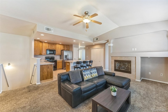 living room featuring visible vents, ceiling fan, vaulted ceiling, and light colored carpet