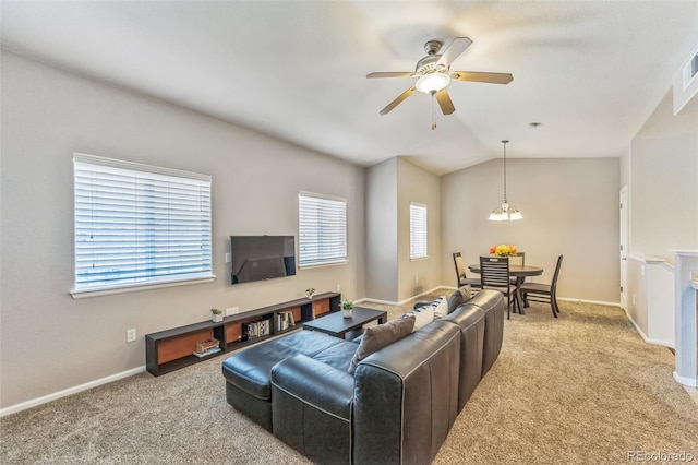living room with baseboards, lofted ceiling, carpet, and ceiling fan with notable chandelier