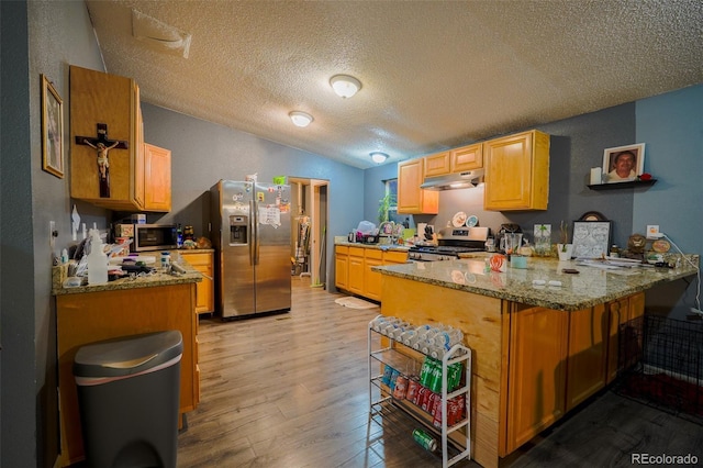15682 Morris Ave, Fort Lupton, CO 80621 - kitchen featuring light wood-style flooring, a peninsula, stainless steel appliances, under cabinet range hood, and stone countertops