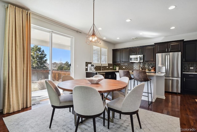 dining space with dark hardwood / wood-style flooring and sink