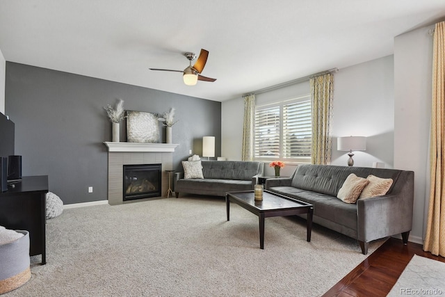 living room featuring a tile fireplace and ceiling fan