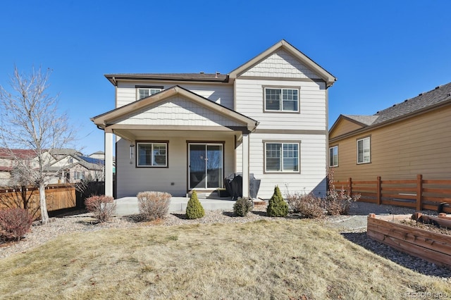 rear view of property featuring a lawn