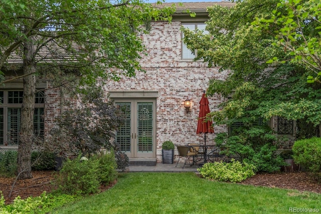 rear view of house with a patio area, a yard, and french doors