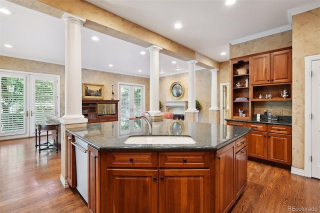 kitchen with dark hardwood / wood-style flooring, a kitchen island with sink, dark stone countertops, and sink