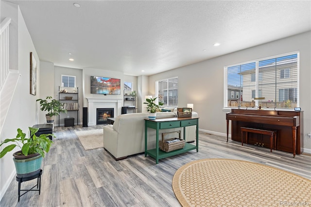 living room featuring light wood-type flooring and a textured ceiling