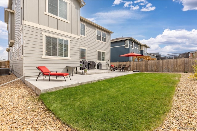 back of house featuring a patio, central AC unit, and a yard