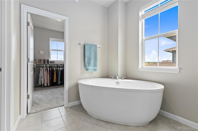 bathroom with a washtub and tile patterned floors