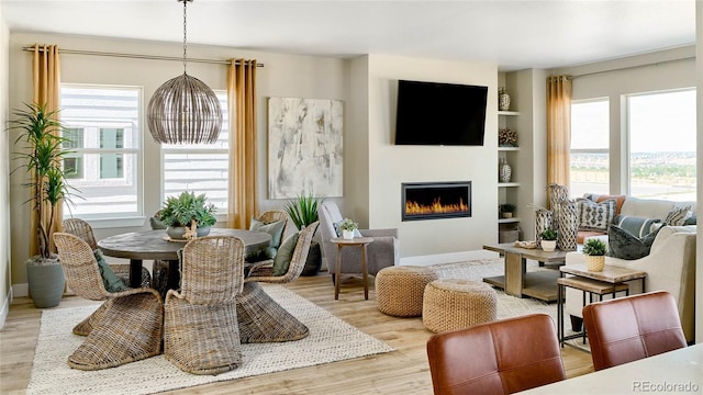 living room with built in features and light hardwood / wood-style flooring