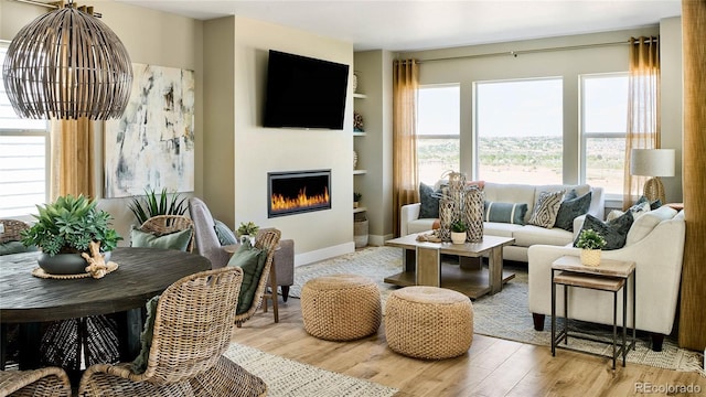 living room featuring light wood-type flooring and built in features