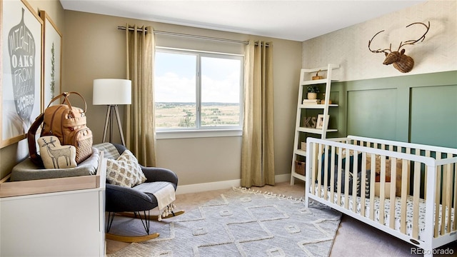 carpeted bedroom featuring a nursery area