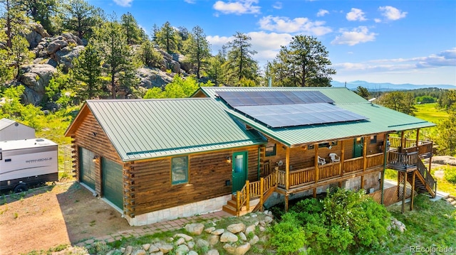 3980 County Rd 71, Guffey, CO 80820 - log home featuring log exterior, stairway, a porch, roof mounted solar panels, and a mountain view