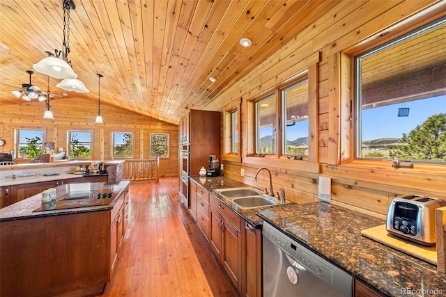 3980 County Rd 71, Guffey, CO 80820 - kitchen with stainless steel appliances, vaulted ceiling, wood walls, wooden ceiling, and brown cabinetry